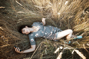 girl lies in dry grass