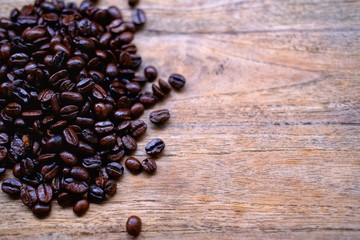 coffee beans in spoon on wooden background