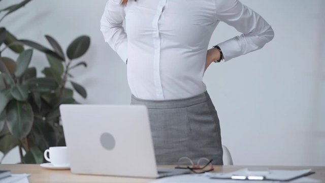 businesswoman stretching back at workplace