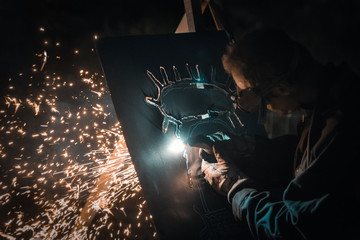 Metal workers use manual labor, Skilled welder, Welder Artist, The welder is welding the steel in...