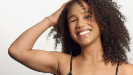 closeup portrait of young mixed race model with curly hair in studio with natural neutral makeup...