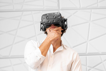 Man wearing virtual reality goggles in modern bright co-working office. the VR experience.