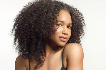 closeup portrait of young mixed race model with curly hair in studio with natural neutral makeup...