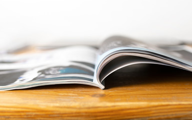 Magazine on wooden table. Beauty or fashion tips and trends. Open page with news article, column or...