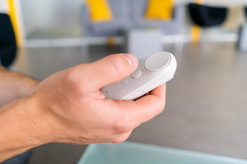 Man holding remote controller of virtual reality goggles