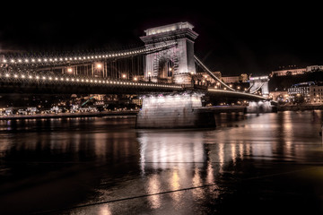 The illuminated Chain Bridge in Budapest with reflection at night on the Danube