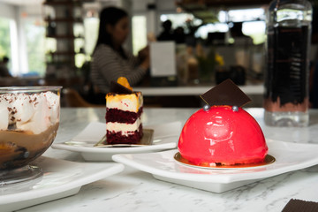 Women eating cakes on white mable table in luxury restaurant.