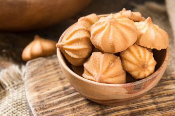 Butter cookies in a wooden bowl on a wooden table