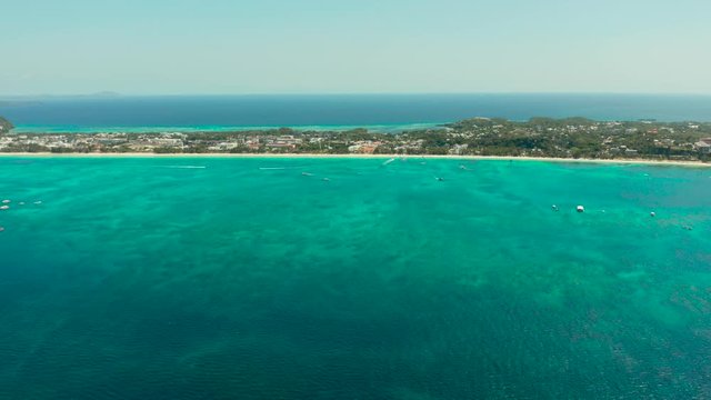 Tropical white sand beach, hotels near the blue lagoon and corall reef. aerial view, Boracay, Philippines. Seascape with beach on tropical island. Summer and travel vacation concept.