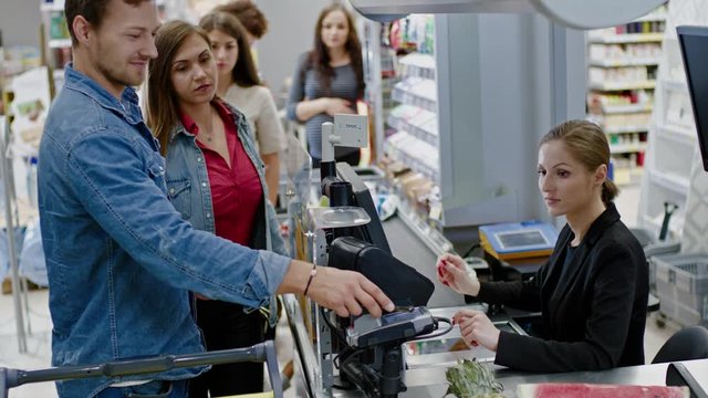 Man paying with a smartphone in a grocery store