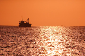 Obraz premium Ship silhouette and sunset