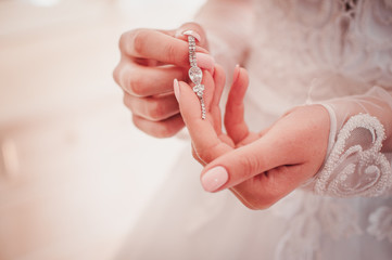 Girl in white dress holding earring in the hands