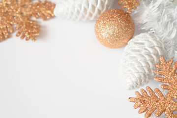 Christmas border with traditional decorations: balls, snowflakes, cones . Selected focus. Christmas composition in gold colors on white background with copy space. Concept for card invitation design