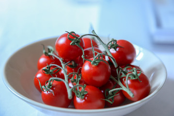 Red ripe tomatoes in white bowl