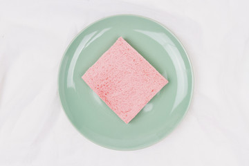 Top view of pink milk flavored sandwich bread on light green plate and white cloth background, soft warm tone, Beautiful breakfast concept.