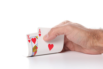 caucasian man's hand showing ace and king hearts poker cards isolated on white background with copy space for your text