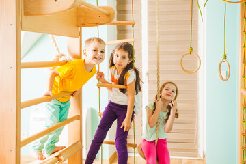 Portrait of smiling kids on a wooden ladder