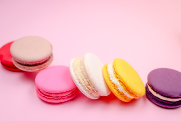 Colorful french macarons (macaroons) cake,  delicious sweet dessert on a pink background with copyspace, food background concept.