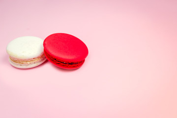 Colorful french macarons (macaroons) cake,  delicious sweet dessert on a pink background with copyspace, food background concept.