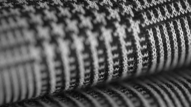 Super macro shot of elegant houndstooth pied de poule fabric folded and laid on a clothing store or in a tailor's. Fashion concept. Closeup.