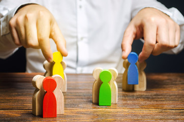 Groups of multicolored wooden people and businessman. The concept of market segmentation. Target...