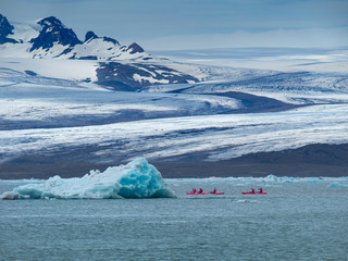 A group of friends in red kayaks near the Jökulsárlón glacier lagoon