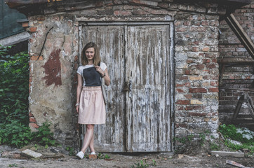 Fototapeta na wymiar A woman stands in front of an old wooden door