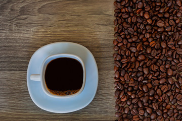 Coffee in a white cup and coffee beans on the table