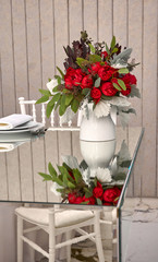 Bouquet of flowers on a mirror table set for fine dining during a celebration. Flower arrangement as a decoration at events