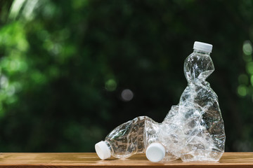 Plastic bottle on wooden in nature background. global warming concept.