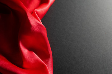 Abstract dark background with red flowing silk.