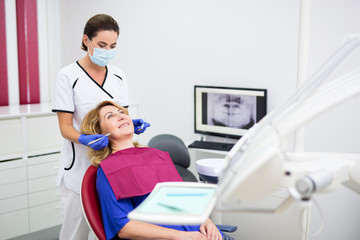 young dentist with happy mature woman patient at clinic