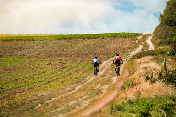 Obraz premium two cyclists riding mountain bike in the countryside