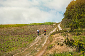 Obraz premium two cyclists riding mountain bike in the countryside