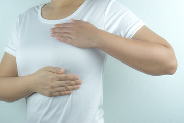 Woman hands doing breast self-exam for checking lumps and signs of breast cancer on white background. Health care and medical concept.