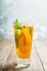 Tasty peach tea in glass on the rustic background. Selective focus. Shallow depth of field.