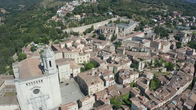 Drone flight over Girona town with formidable ancient gothic building, Cathedral of Santa Maria, widest in world. Aerial shot of medieval quarter on background of scenic cityscape, Catalonia, Spain