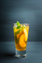 Tasty peach tea in glass on the rustic background. Selective focus. Shallow depth of field.