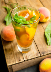 Tasty peach tea in glass on the rustic background. Selective focus. Shallow depth of field.