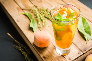 Tasty peach tea in glass on the rustic background. Selective focus. Shallow depth of field.