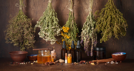 Drying medical herbs, honey, spices and bottle with essential oil for use in alternative medicine