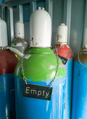 An empty gas bottle in a storage room full of gas bottles.