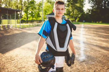 A children baseball catcher players standing on the playground
