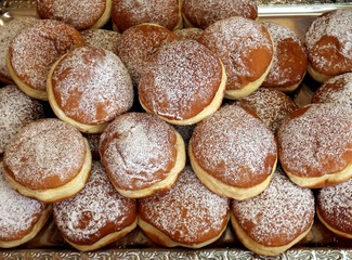 Top view of many Krapfen, also known as Berliner,  on a tray of a pastry shop. It is traditional german doughnut 
