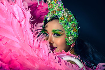 Show beautiful woman with fantasy dress and head gear for performance on background