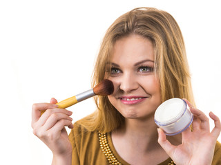 Smiling woman applying face powder