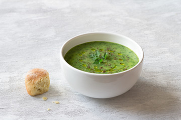 Healthy green kale cream soup with potatoes and bread on gray background with free space. simple homemade food