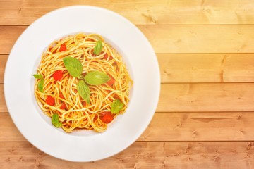 Spaghetti pasta with tomatoes and parsley on  table.