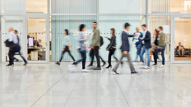 Viele verschwommene Menschen gehen durch B&uuml;ro