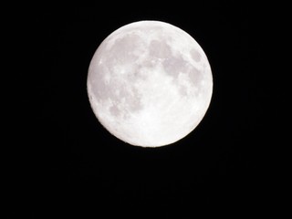 Genova, Italy - 09/12/2019: An amazing photography of the full moon over the city of Genova by night with a great clear sky in background and some stars